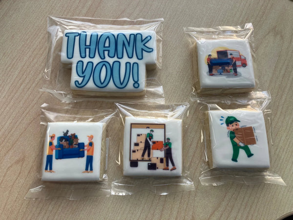 Five individually wrapped square cookies decorated with moving-themed illustrations and a large 'THANK YOU!' message, arranged on a light wood surface.